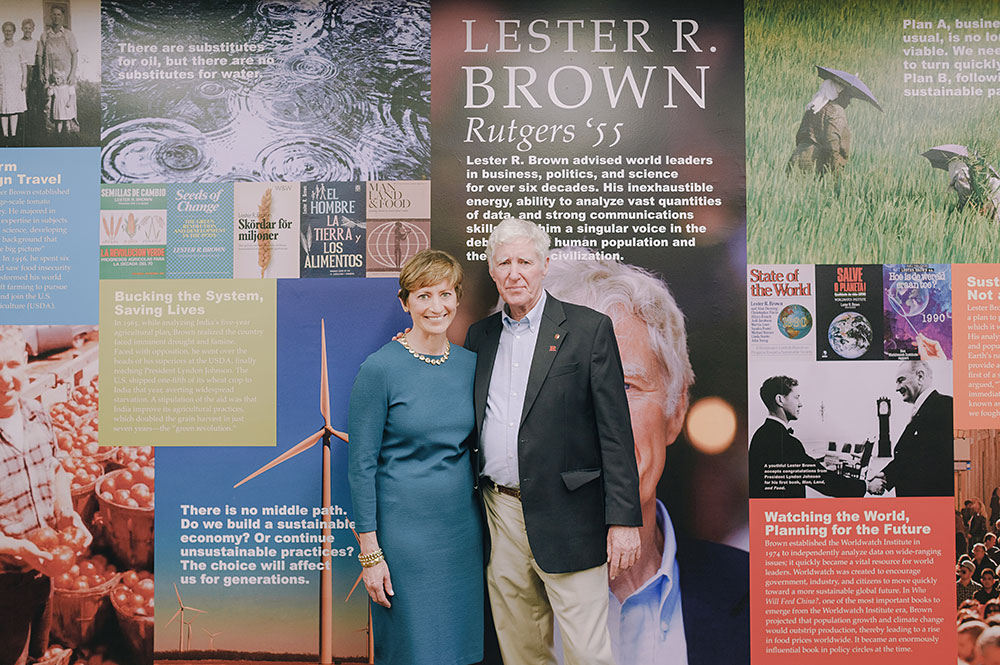 Lester R. Brown and another person standing in front of a wall-sizxed mural in teh Lester R. Brown Reading Room.